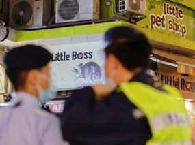 Des policiers montent la garde devant une animalerie temporairement fermée après que le gouvernement a annoncé l'euthanasie d'environ 2 000 hamsters dans la ville après avoir trouvé pour la première fois des preuves d'une éventuelle transmission de l'animal à l'homme de la maladie à coronavirus à Hong Kong, le 18 janvier 2022.