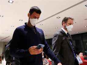 Le joueur de tennis serbe Novak Djokovic se promène à l'aéroport de Melbourne avant d'embarquer sur un vol, après que la Cour fédérale a confirmé la décision du gouvernement d'annuler son visa pour jouer à l'Open d'Australie, à Melbourne, Australie, le 16 janvier 2022.