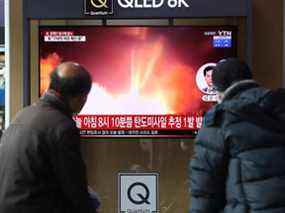 Des gens regardent une télévision à la gare de Séoul montrant une image d'un fichier de lancement de missile nord-coréen, le 5 janvier 2022 à Séoul, en Corée du Sud