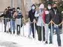     Les gens portent des masques faciaux en attendant d'être testés pour le COVID-19 dans une clinique de Montréal, le dimanche 3 janvier 2021, alors que la pandémie de COVID-19 se poursuit au Canada et dans le monde.