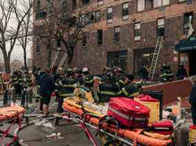 Les premiers intervenants d'urgence restent sur les lieux d'un incendie intense dans un immeuble résidentiel de 19 étages qui a éclaté dans le quartier du Bronx à New York, le dimanche 9 janvier 2022.