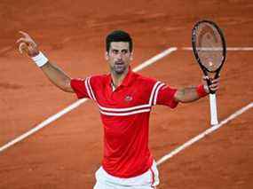 Le Serbe Novak Djokovic célèbre sa victoire contre l'Espagnol Rafael Nadal à l'issue de la demi-finale du simple messieurs à l'Open de France 2021 à Paris le 11 juin 2021.