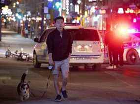 Jiayuan promène son chien Dex sur la rue Sainte-Catherine alors que la police de Montréal arrête et vérifie les personnes voyageant en paires ou en groupes après le couvre-feu le 11 avril 2021.