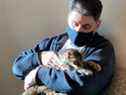 Brandy, un chat tigré brun, le lundi 22 février 2021, avec son propriétaire, Charles, au centre de soins pour animaux de Palmdale, en Californie. 