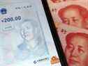 L'application officielle chinoise pour le yuan numérique sur un téléphone mobile à côté des billets de 100 yuans.