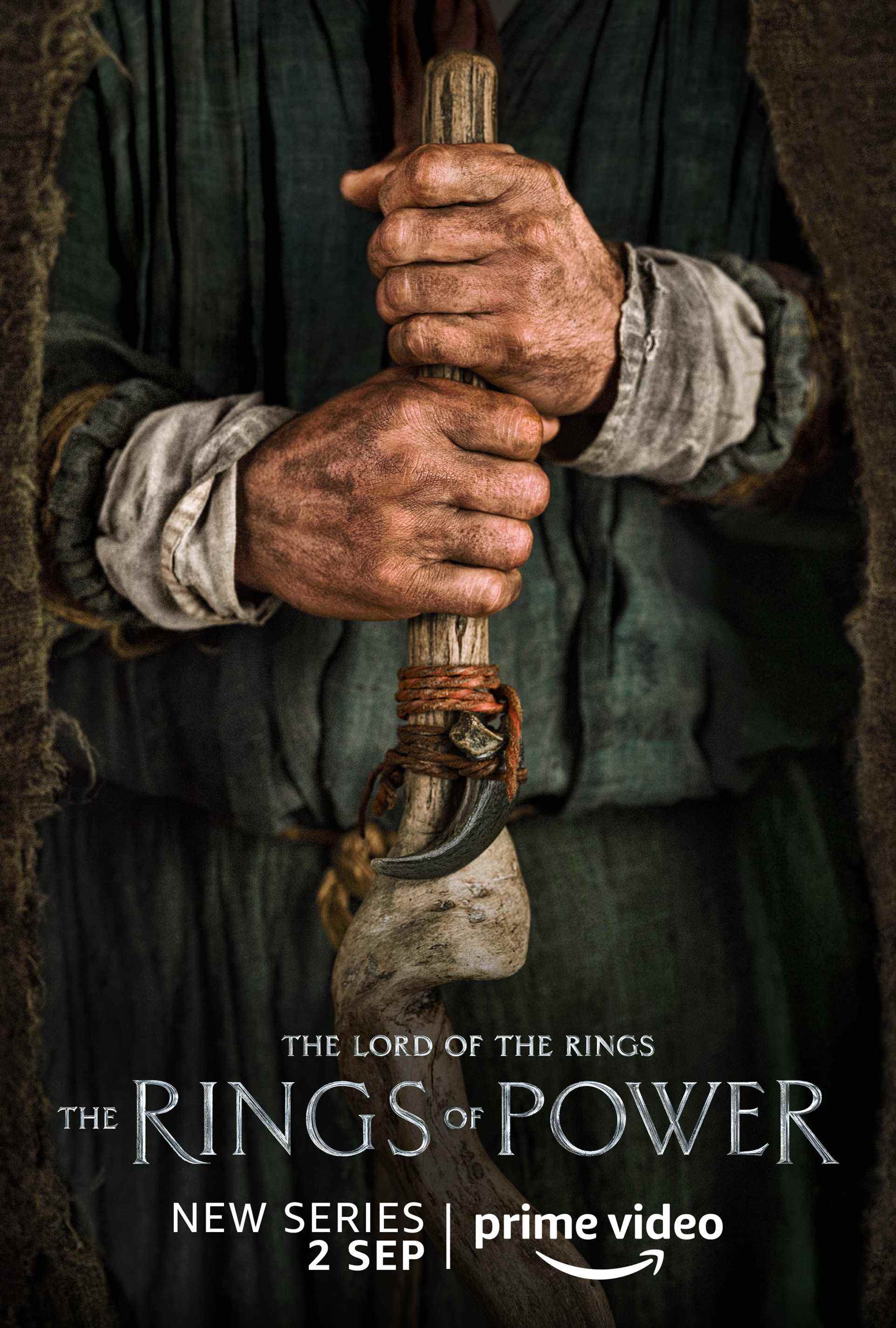 Une personne tenant une affiche de personnage de club pour Lord of the Rings: The Rings of Power