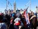 Une personne porte un drapeau de bataille confédéré devant la colline du Parlement alors que des camionneurs et des partisans participent à un convoi pour protester contre les mandats de vaccination contre la maladie à coronavirus (COVID-19) pour les chauffeurs de camion transfrontaliers à Ottawa, Ontario, Canada, le 29 janvier 2022.