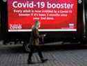 Une femme portant un masque facial passe devant un écran publicitaire mobile encourageant les gens à se faire vacciner contre la COVID-19 à Bolton, en Grande-Bretagne, le 18 décembre 2021. REUTERS/Phil Noble