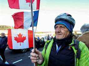 Un militant français tient un drapeau canadien avant le début de leur « Convoi de la liberté », mercredi à Nice, en France.