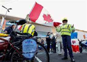 Un militant français affiche un drapeau canadien avant le début de leur « Convoi de la liberté », une manifestation de véhicules convergeant vers Paris pour protester contre les restrictions du COVID-19 à Nice, en France, le mercredi 9 février 2022.