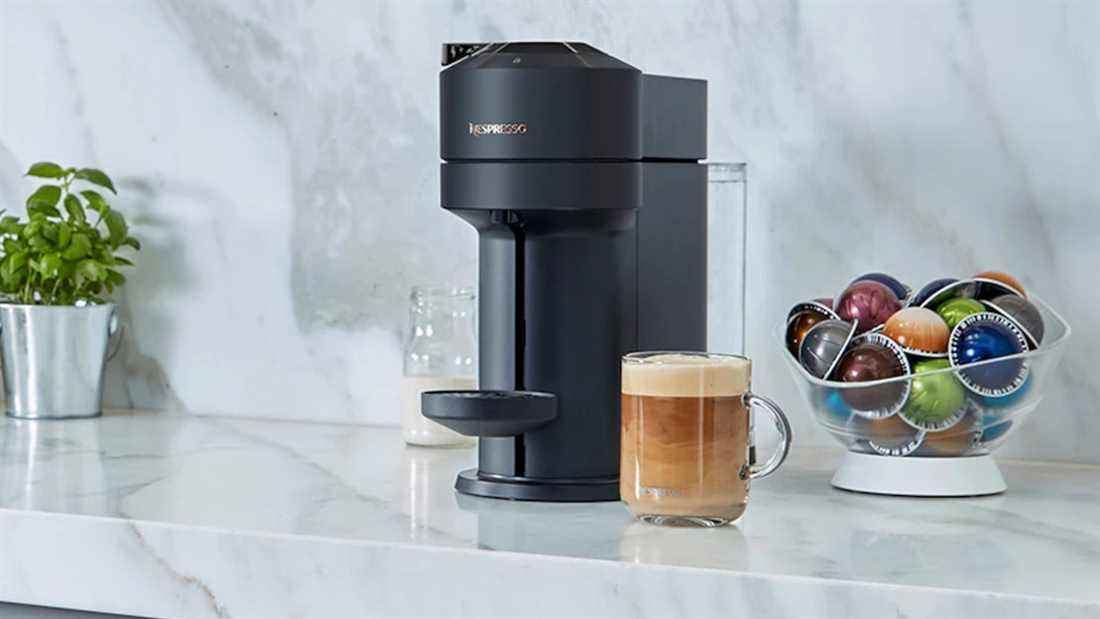 La Nespresso Vertuo Next sur un comptoir entouré de café et de capsules Vertuo