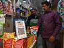 Un homme fait ses courses dans une épicerie où un code-barres pour Paytm, une plate-forme indienne de paiement numérique basée sur un téléphone portable, est affiché sur un marché de New Delhi.
