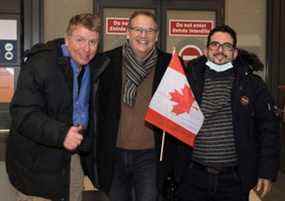 Le chroniqueur du Toronto Sun Joe Warmington, lieutenant-colonel à la retraite des Forces canadiennes.  Tony White et Ahmad Seyar Sadiqi, alias Radar, après l'arrivée de l'interprète afghan avec sa famille à Ottawa le jeudi 11 février 2022.