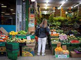 Un client achète des fruits et légumes dans un magasin de fruits et légumes à Walthamstow, dans l'est de Londres.