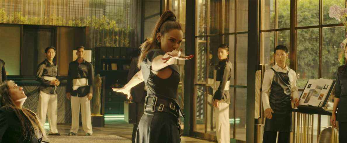 Rhatha Phongam dans le rôle de Ku An Qi fait des gestes spectaculaires dans un dojo aux parois de verre dans Fistful of Vengeance