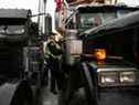 Un policier monte sur le siège passager d'un camion klaxonnant à Ottawa jeudi. 