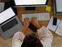 Une femme travaille sur un ordinateur de bureau à côté d'un ordinateur portable Apple Inc. dans un bureau à domicile sur cette photo arrangée prise le samedi 22 août 2020.