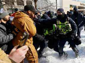 La police repousse lors d'un ratissage contre la manifestation du Freedom Convoy à Ottawa, le 18 février 2022.