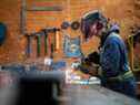 Un ouvrier broie un assemblage d'acier chez Macon Industries à Parksville, en Colombie-Britannique.