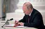 Le président russe Vladimir Poutine signe des documents, dont un décret reconnaissant deux régions sécessionnistes soutenues par la Russie dans l'est de l'Ukraine en tant qu'entités indépendantes, lors d'une cérémonie à Moscou, sur cette photo publiée le 21 février 2022.  