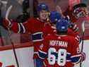 Cole Caufield (22 ans) des Canadiens de Montréal célèbre son but avec ses coéquipiers Nick Suzuki (14 ans) et Mike Hoffman contre les Sabres de Buffalo, lors de la troisième période à Montréal le 23 février 2022. 
