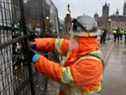 Les travailleurs construisent une clôture autour du bâtiment du Parlement alors qu'une manifestation organisée par des camionneurs opposés aux mandats de vaccination se poursuit le 17 février 2022 à Ottawa.