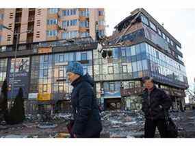 Des femmes passent devant l'immeuble du 6A, avenue Lobanovsky, qui a été touché par un missile le 26 février 2022 à Kiev.