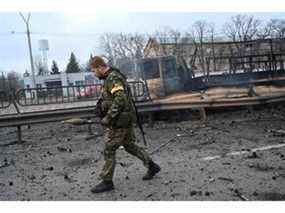 Des militaires ukrainiens récupèrent des obus non explosés après un combat avec un groupe de raids russes dans la capitale ukrainienne de Kiev dans la matinée du 26 février 2022, selon le personnel des services ukrainiens sur les lieux.