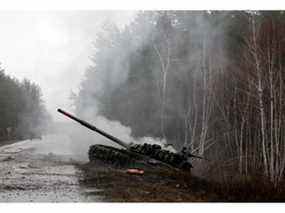 De la fumée s'élève d'un char russe détruit par les forces ukrainiennes sur le bord d'une route dans la région de Lougansk le 26 février 2022.