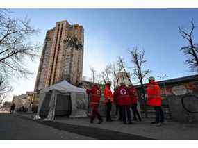 Des médecins se rassemblent près d'un immeuble d'habitation qui a été touché par un récent bombardement à Kiev le 26 février 2022.