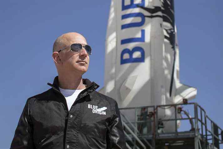 Le fondateur d'Amazon, Jeff Bezos, se tient devant une fusée Blue Origin.