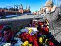 Des gens déposent des fleurs sur le site où feu le chef de l'opposition Boris Nemtsov a été abattu sur un pont près du Kremlin, dans le centre de Moscou, le 27 février 2022, à l'occasion du septième anniversaire de son assassinat.