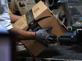 Un travailleur assemble une boîte pour la livraison au centre de distribution d'Amazon à Baltimore, Maryland.