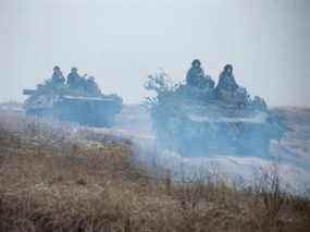 Des militaires ukrainiens montent au sommet de véhicules blindés lors d'exercices tactiques sur un terrain d'entraînement dans un lieu inconnu en Ukraine, sur cette photo publiée le mardi 22 février 2022.