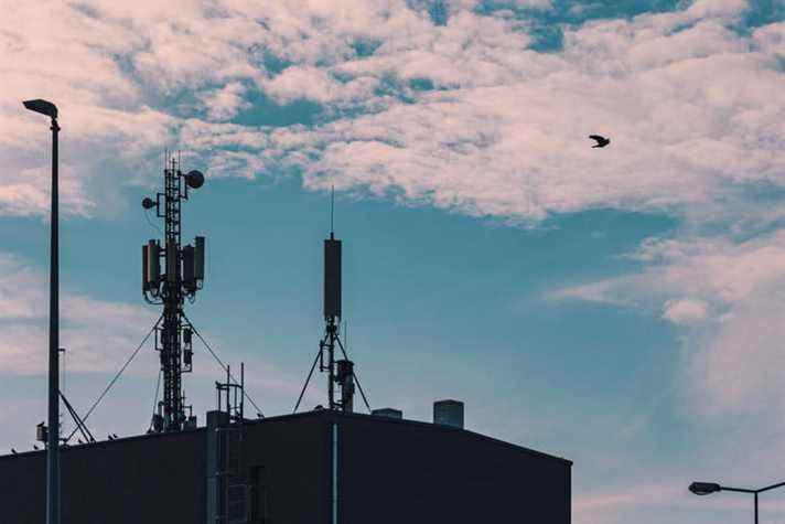 Tours radio cellulaires sur le toit du bâtiment contre le ciel avec des nuages.