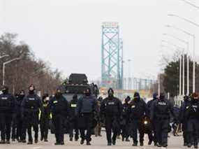Des policiers se déplacent le long d'une route menant au pont Ambassador, qui relie Detroit et Windsor, après avoir éliminé les manifestants, lors d'une manifestation contre les mandats de vaccination contre la maladie à coronavirus (COVID-19), à Windsor, Ontario, Canada le 13 février 2022. REUTERS/Carlos Osorio
