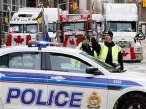 La police patrouille une barricade tandis que des véhicules bloquent les rues du centre-ville, alors que les camionneurs et les partisans continuent de protester contre les mandats de vaccination contre la COVID-19, à Ottawa, le jeudi 3 février 2022.