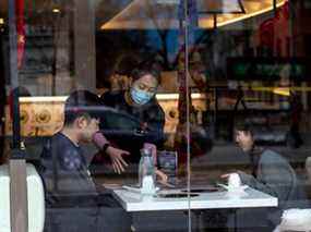 Un serveur s'occupe des clients dans un restaurant du quartier chinois du centre-ville de Toronto.