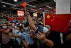 Des supporters agitent des drapeaux nationaux chinois en attendant l'arrivée du dirigeant de Huawei, Meng Wanzhou, à l'aéroport international de Bao'an à Shenzhen.