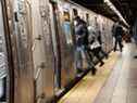 Les gens montent à bord d'un métro le 19 janvier 2022 à New York. 