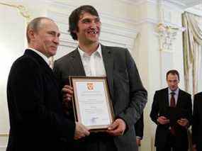 Le président russe Vladimir Poutine détient un certificat avec Alexander Ovechkin, membre de l'équipe nationale russe de hockey sur glace, à la résidence Novo-Ogarevo à l'extérieur de Moscou le 29 mai 2012.