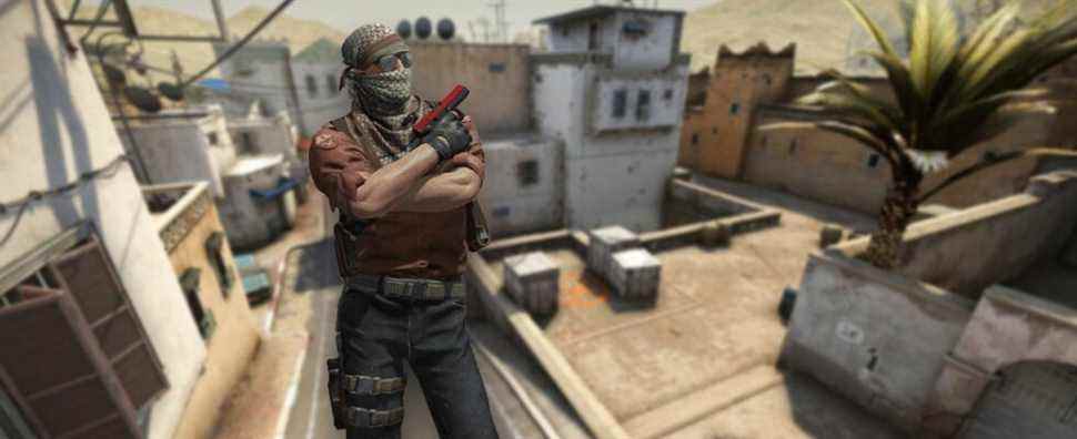 A CS:GO Terrorist showing his pistol with Dust 2 in the background