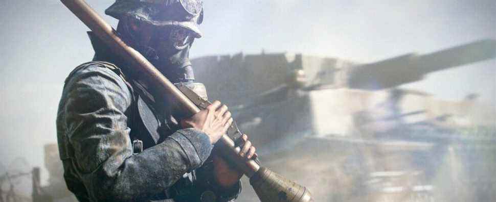 Assault class soldier holds a rocket while wearing a gas mask, with tank in background. From Battlefield 5