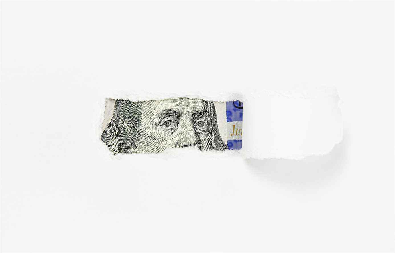 Portrait de Benjamin Franklin sur un billet de cent dollars dans un trou de papier déchiré, gros plan