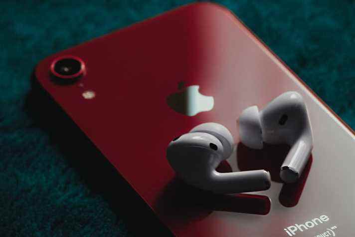 Les AirPods Pro placés sur un iPhone rouge.