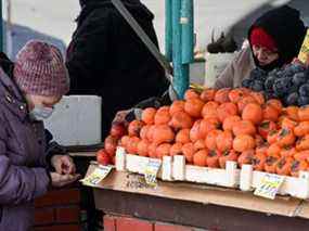 Une femme achète des fruits sur un marché à Moscou.