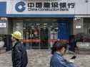 Des piétons passent devant une succursale de China Construction Bank Corp. à Shanghai, en Chine. 