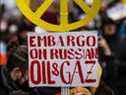 Un manifestant anti-guerre affiche une pancarte appelant à un embargo sur le pétrole et le gaz russe lors d'un rassemblement à Berlin.
