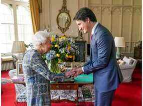 La reine Elizabeth II de Grande-Bretagne serre la main du Premier ministre canadien Justin Trudeau lors d'une audience au château de Windsor, dans le Berkshire, le 7 mars 2022.