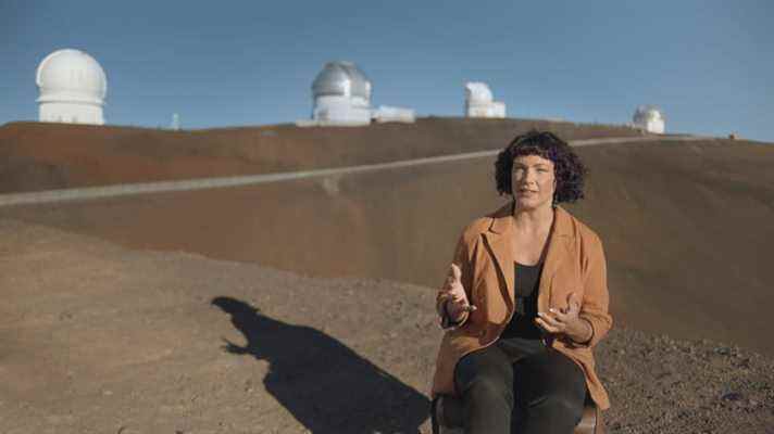 L'astronome Lucianne Walkowicz parle avec des stations de recherche dans l'espace lointain vues en arrière-plan.